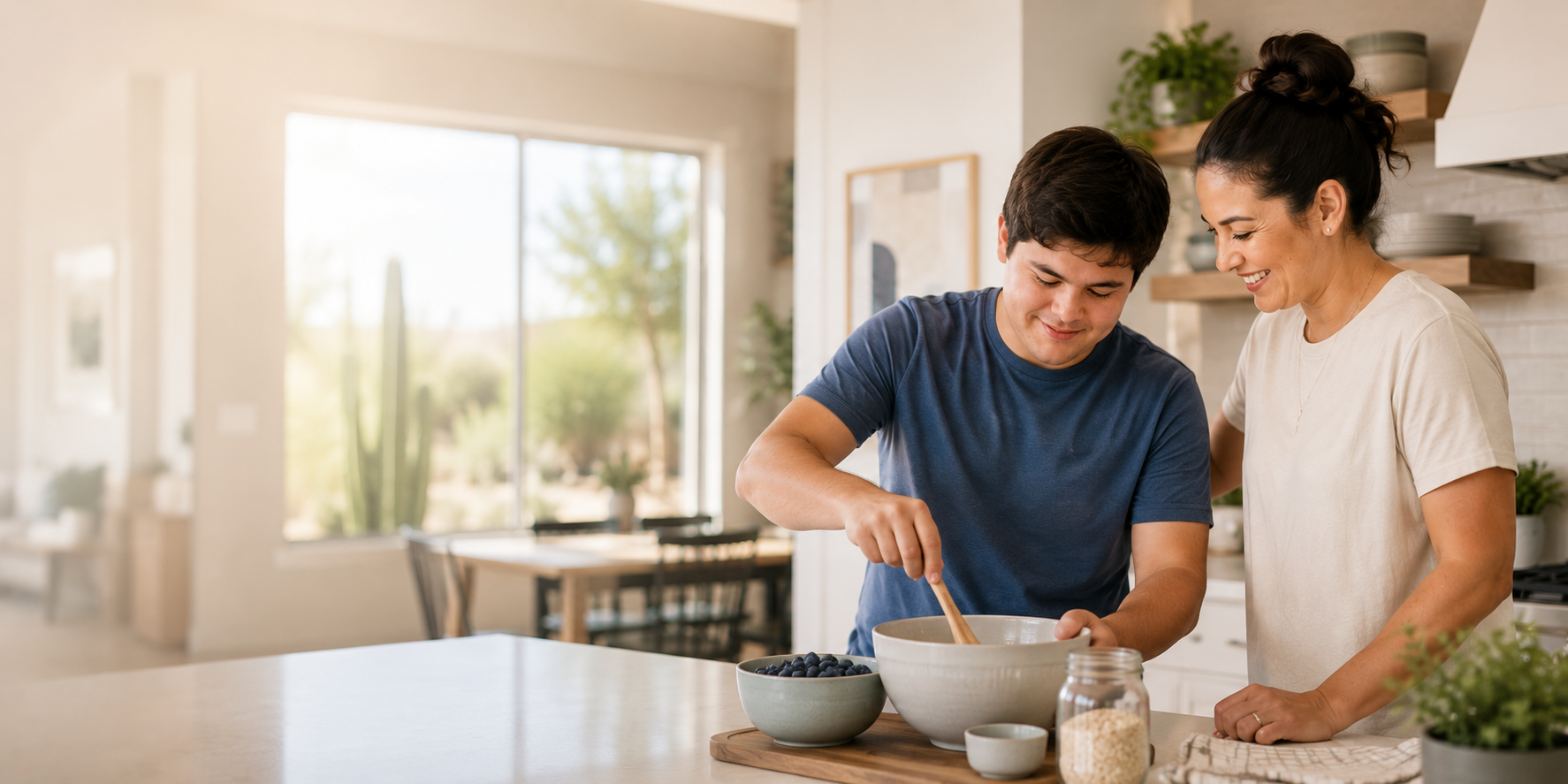 A caregiver and a young man baking together in a home kitchen